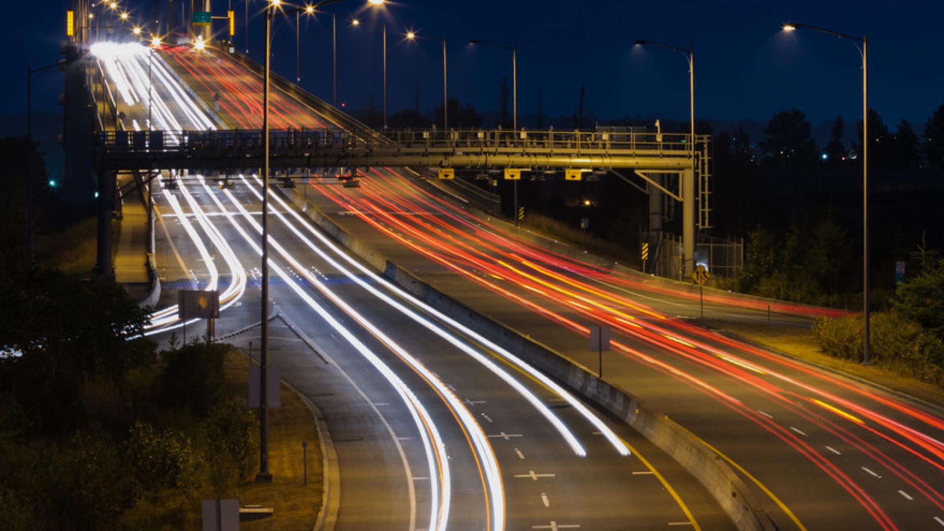 Vehicle tail and headlights snake up the Golden Ears Bridge in a long exposure.
