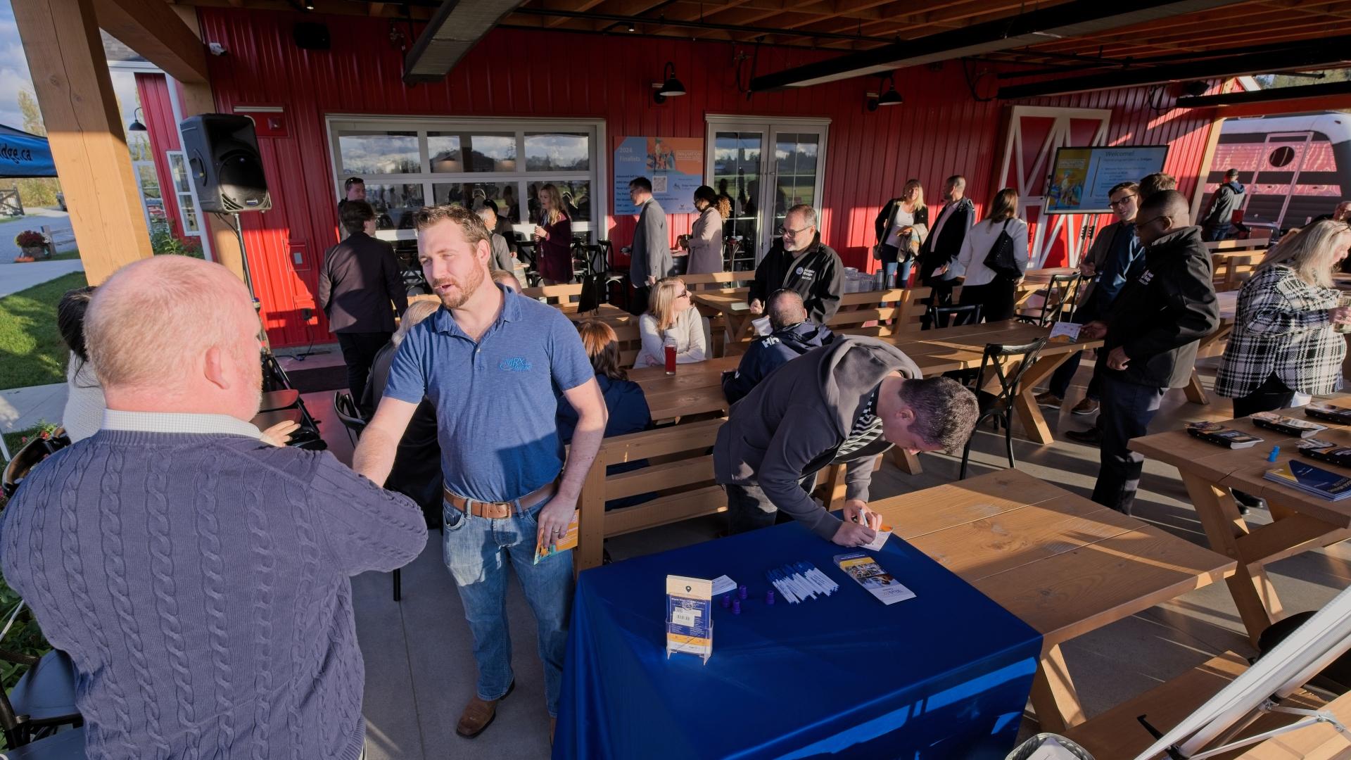 A man reached out for a handshake at an information booth set up at the Innovation Challenge 2024 awards event.