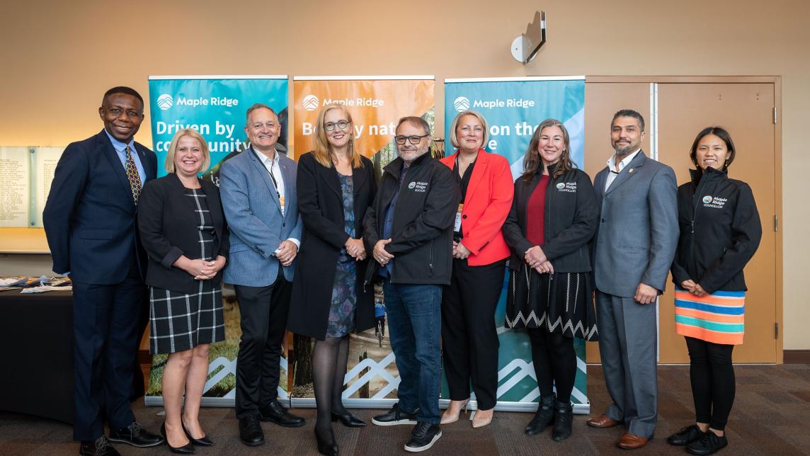 A mix of councillors and, presumably, conference speakers pose together for a photo in front of the event banners.