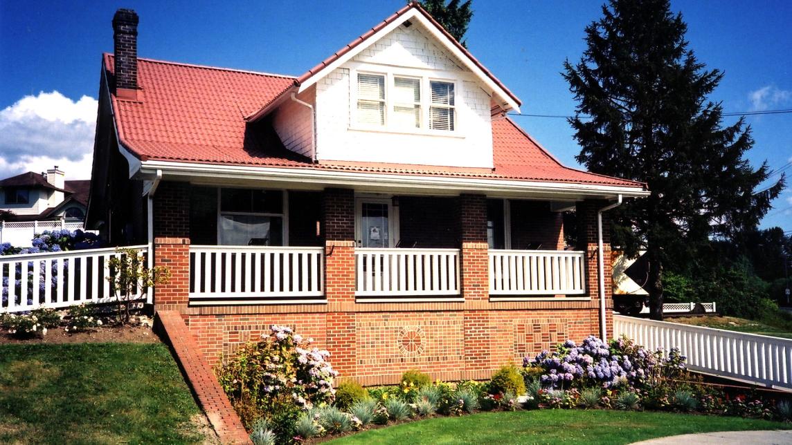 A large brick building with a red roof and white trim houses the Maple Ridge Museum.