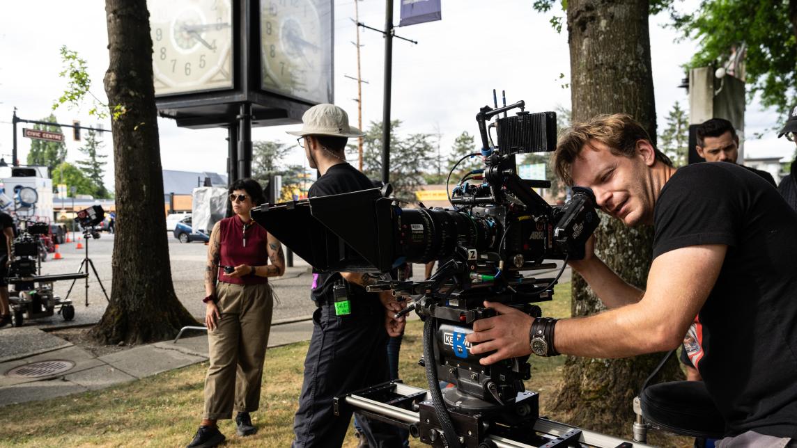 A film crew member operates a camera in front of "The Beast" clock in Maple Ridge