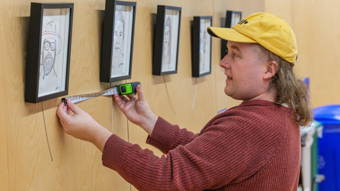 Alex Neff measures the distance between portraits as part of their Constellation display.