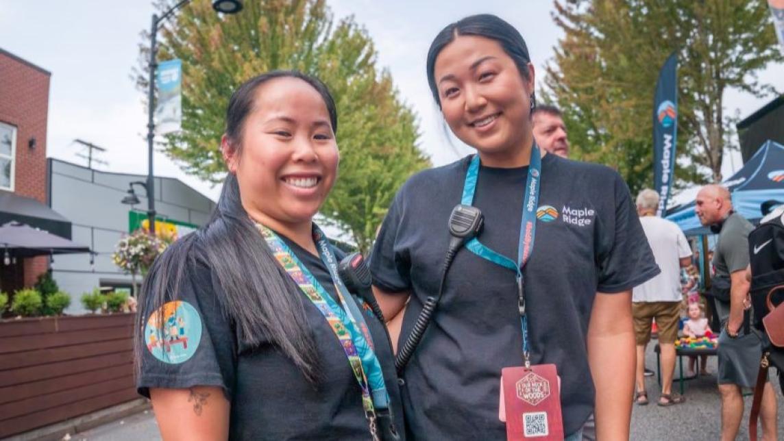 Image of two staff members attending the event, our neck of the woods.