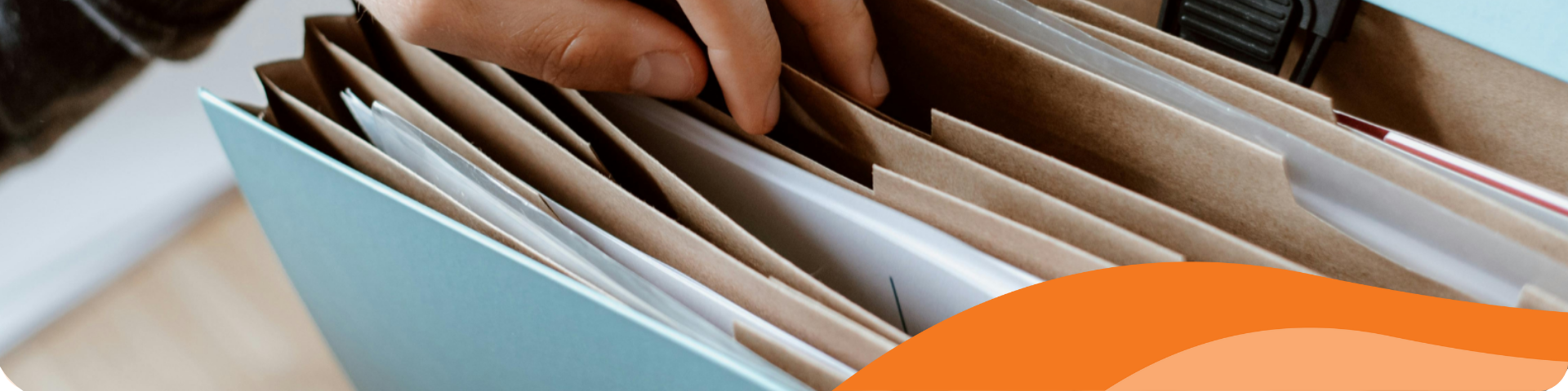 A person flips through a file folder.