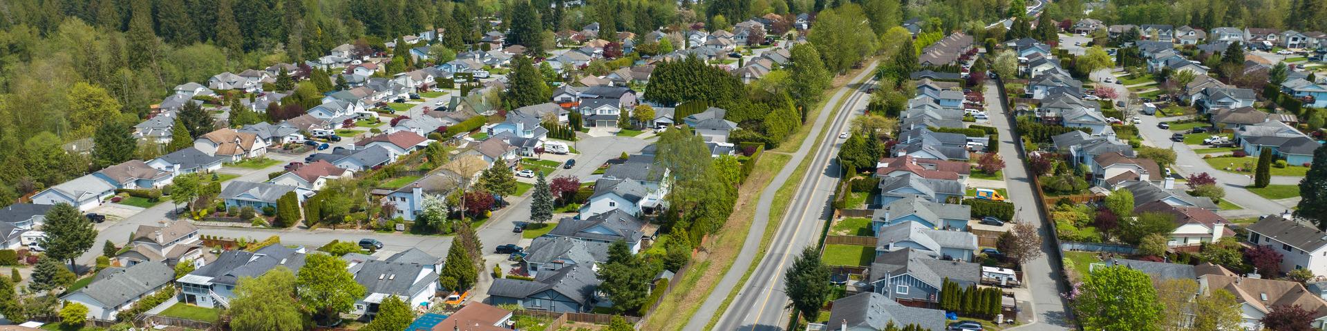 An aerial view of a road winding between two large residential areas of Maple Ridge.
