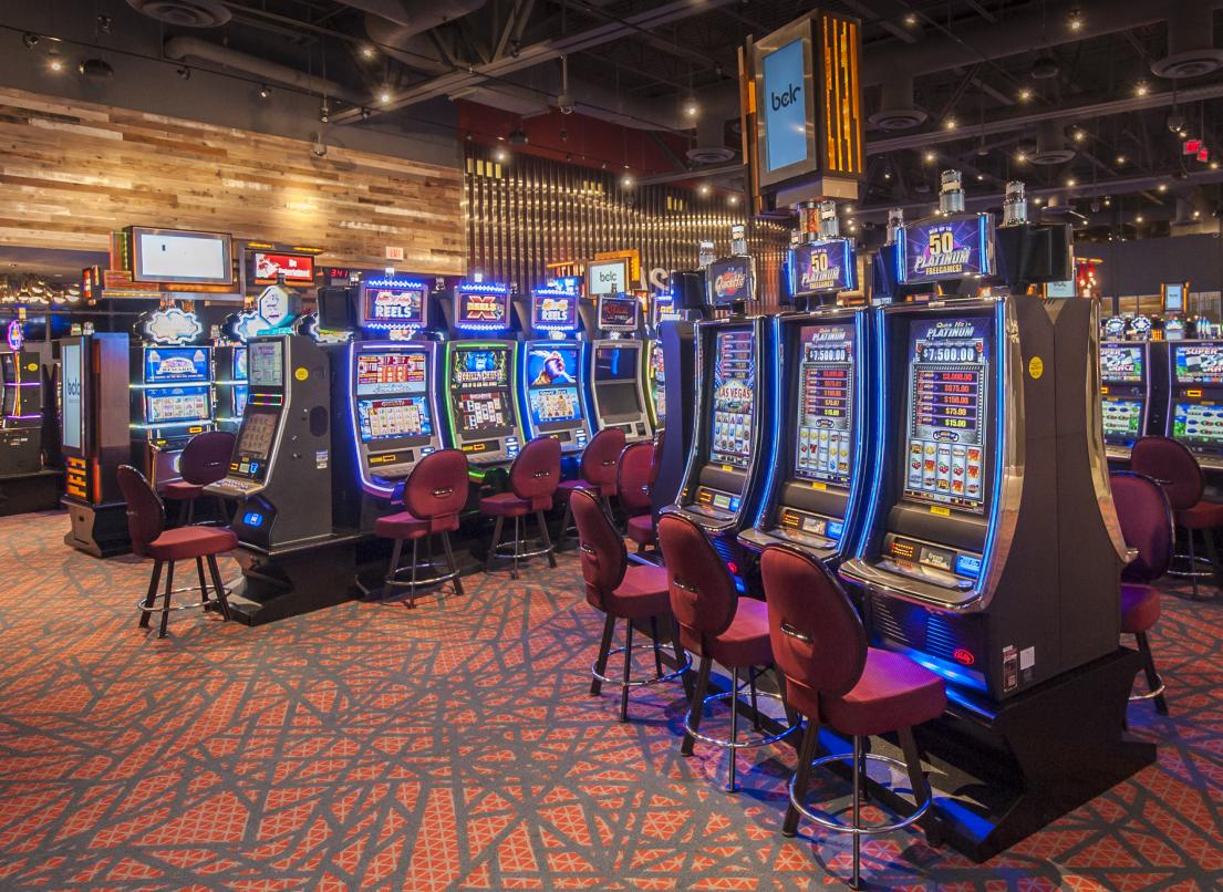 Rows of slot machines sit empty, awaiting players in a casino.