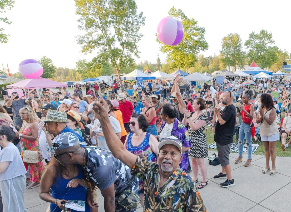 A crowd of diverse people gathers for the next event at the Caribbean Festival.