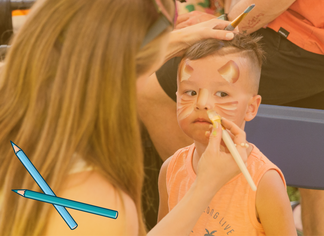 Face Painter Doing An Animal Face on a Little Boy