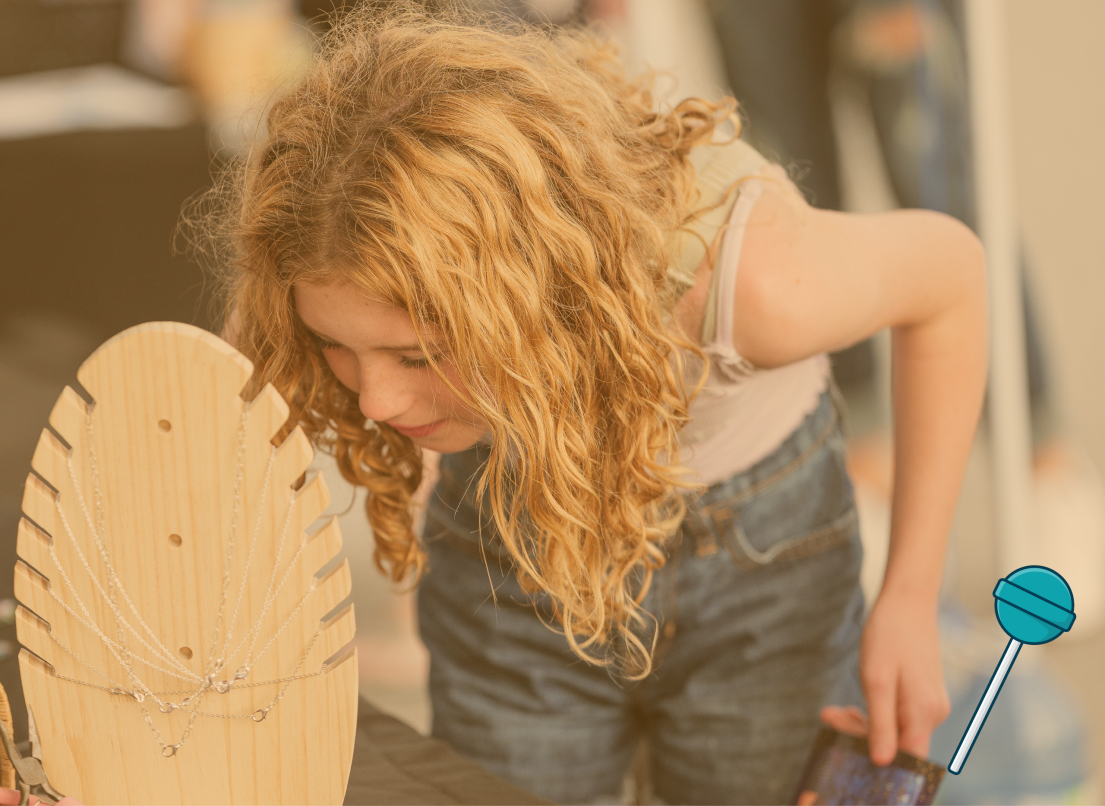 Young Girl Looking at Items at a Vendor Stand