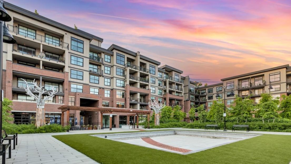 The sunset lights up the sky above the courtyard at the Brickwater at the Village, a welcoming green space surrounded by apartments.