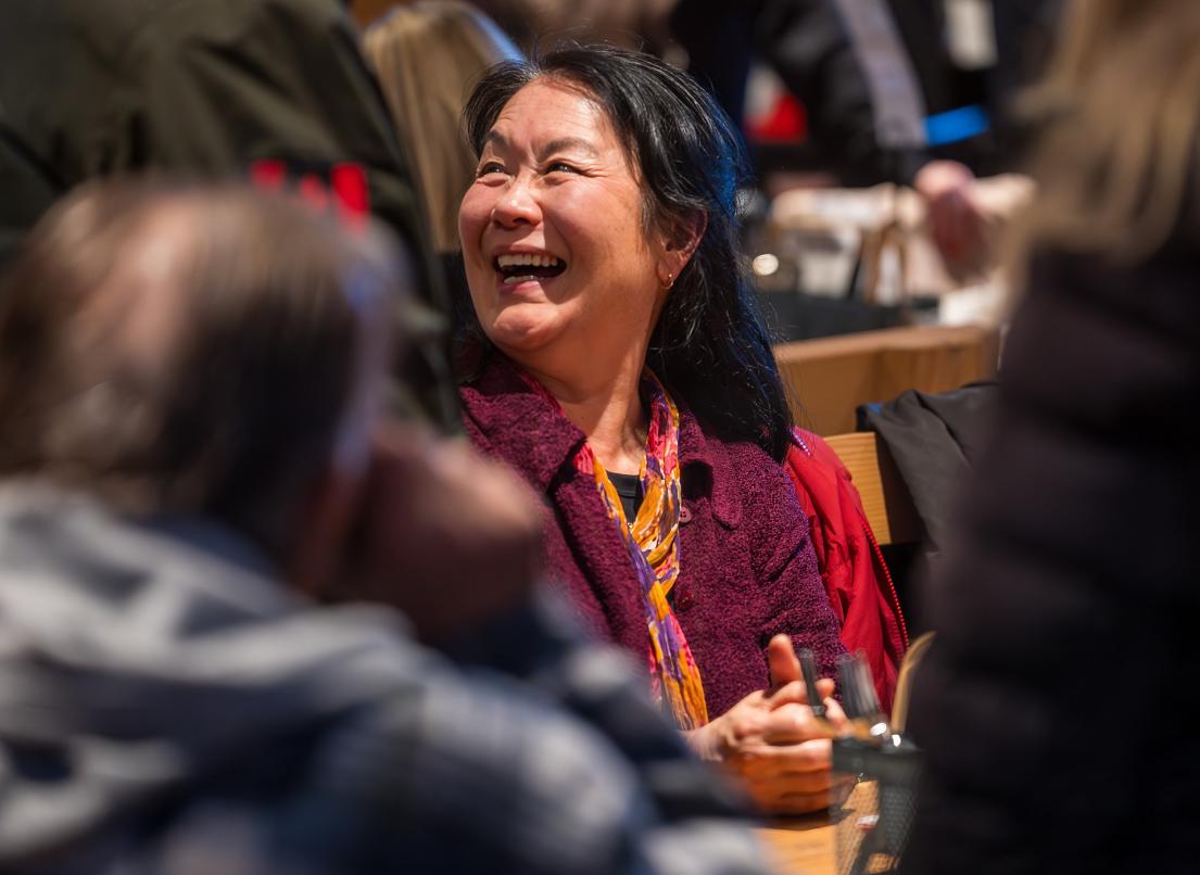A woman smiles widely as she talks with peers at the Innovation Challenge 2025 event.