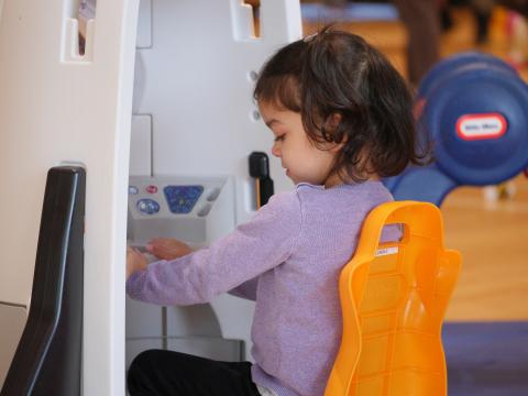 Little Girl Playing with Play Equipment in a Gym