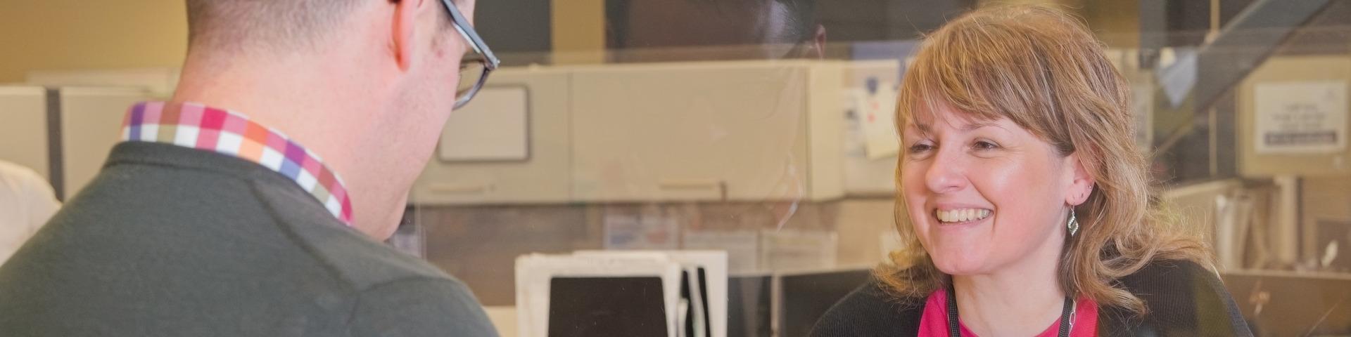 A city worker gives a large smile to a customer.