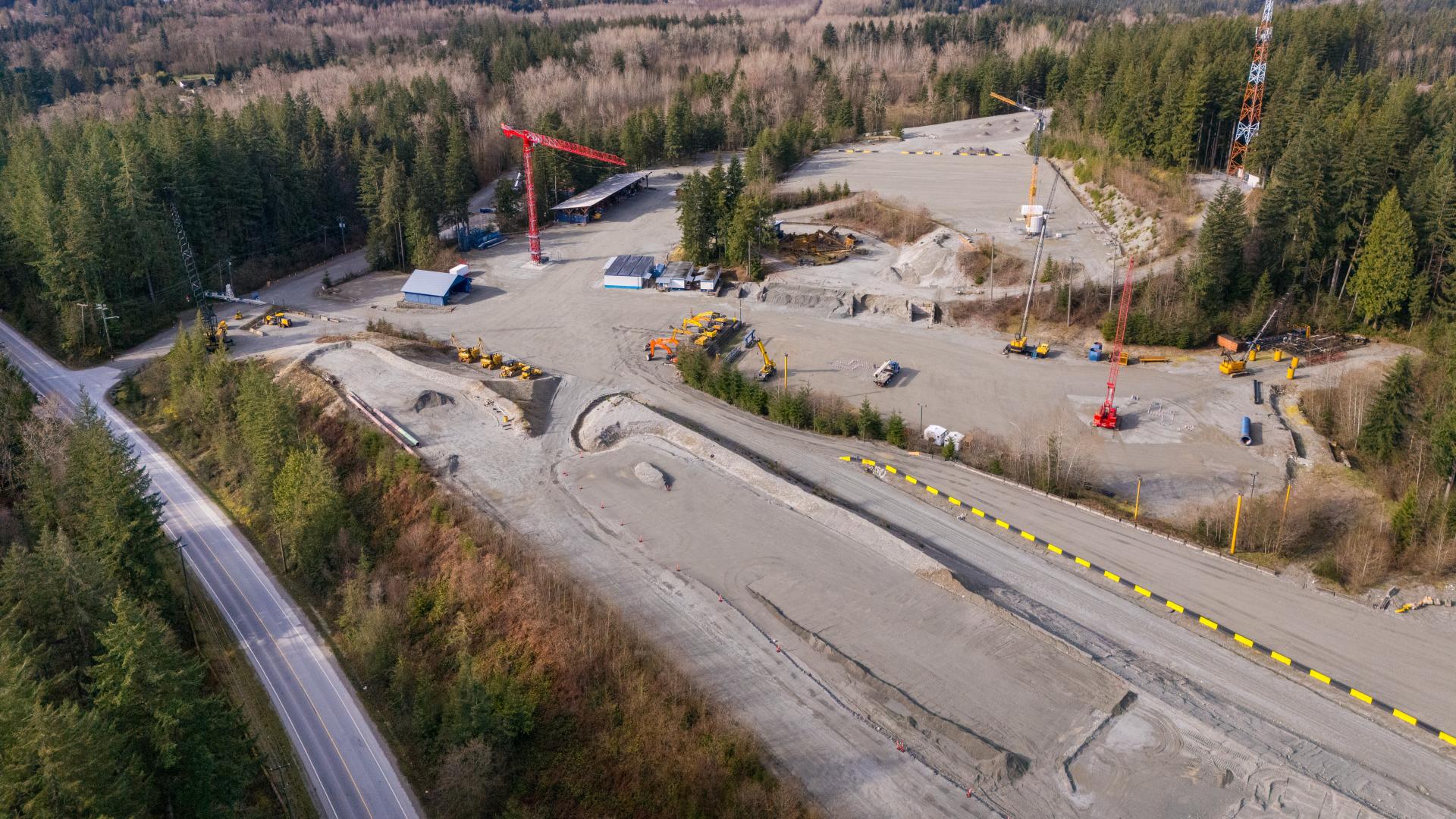 An aerial of a construction site with industrial cranes alongside the 256th street.