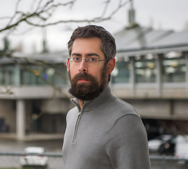 Dominic Vogel wears a grey sweater outdoors on a cloudy day.