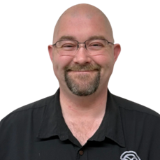 Steven DeBoer smiles broadly at the camera while wearing a black collared shirt.