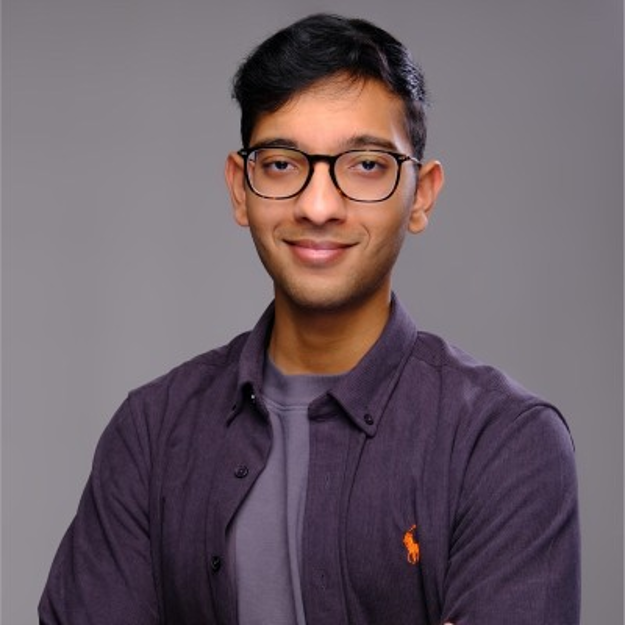 Shantanu Mehta smiles at the camera while wearing casual purple shirts.
